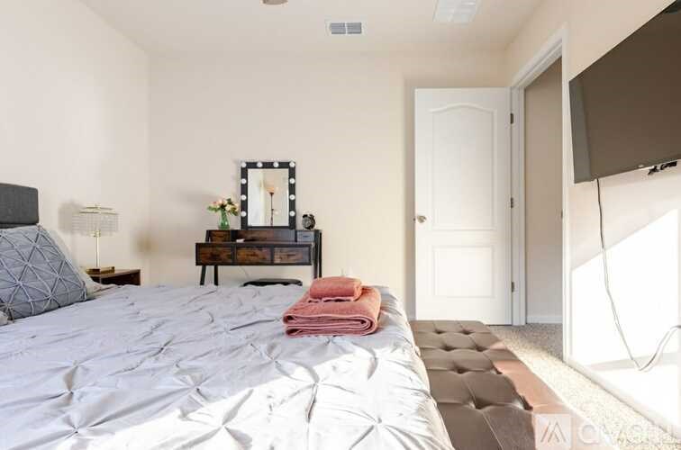 A bedroom with a large bed and a mirror on the wall.