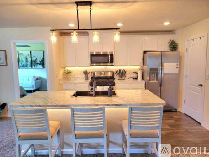 A kitchen with a table and chairs in front of it.