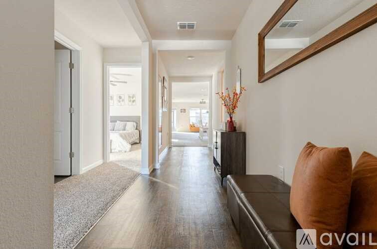 A long hallway with a brown couch and a mirror on the wall.