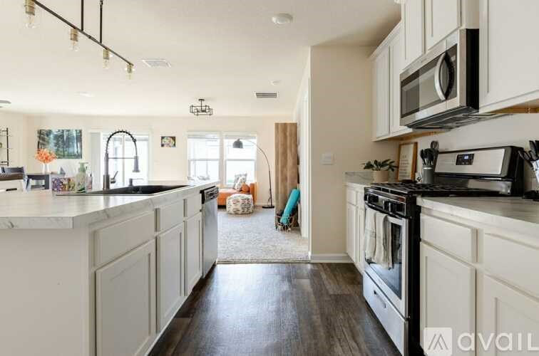 A kitchen with white cabinets and black appliances.