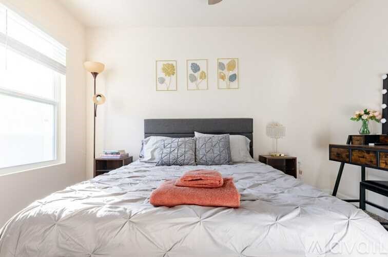 A bedroom with a large bed and a window.