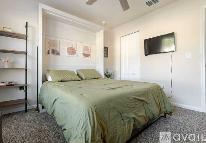 A bedroom with a bed, a television, and a wall with pictures of human organs.