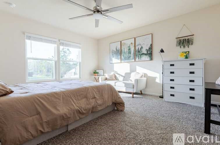 A bedroom with a bed, a chair, and a dresser.