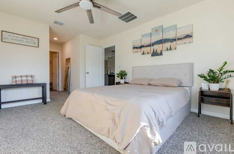 A bedroom with a large bed and a ceiling fan.