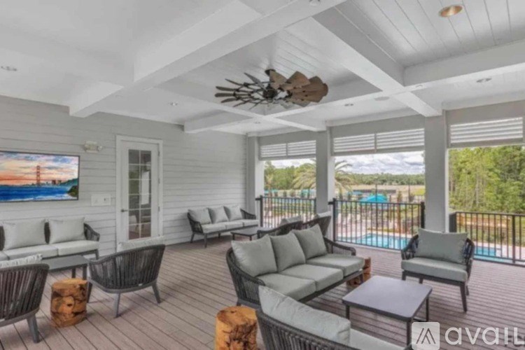 A living room with a pool in the background.