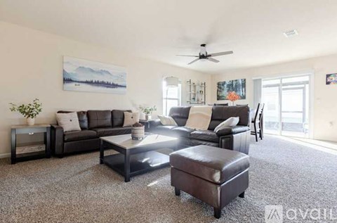 A living room with a brown leather sofa and a coffee table.