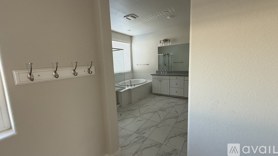 A bathroom with a tub, sink, and towel rack.