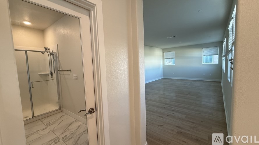 A bathroom with a walk-in shower and a door leading to a hallway.