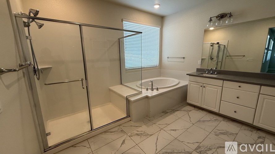 A bathroom with a glass shower stall, a bathtub, a sink, and a mirror.
