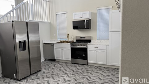 A kitchen with a black fridge and stove top oven.