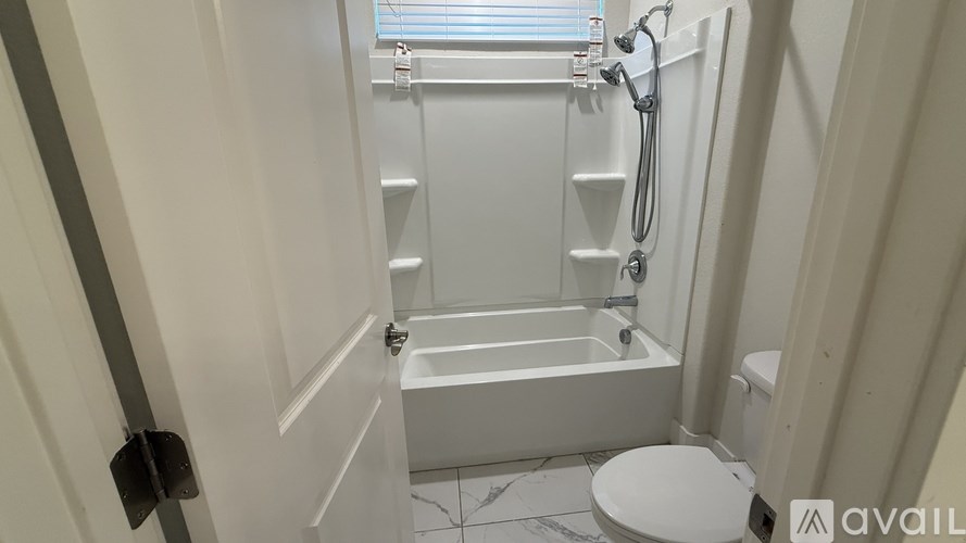 A white bathroom with a toilet, sink, and bathtub.