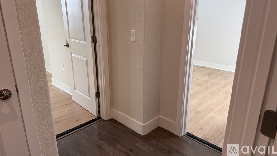 A hallway with a door on the left and a door on the right.