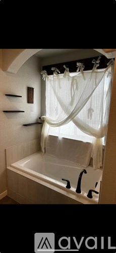 A white bathtub with a white shower curtain.