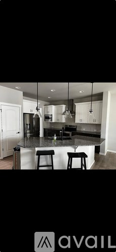 A modern kitchen with a large island and stools.