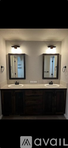 A bathroom with two sinks and two mirrors.