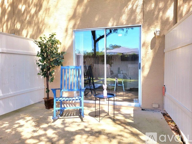 A blue chair sits in a sunny backyard.