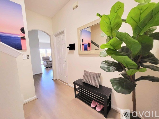 A living room with a bench and a plant.