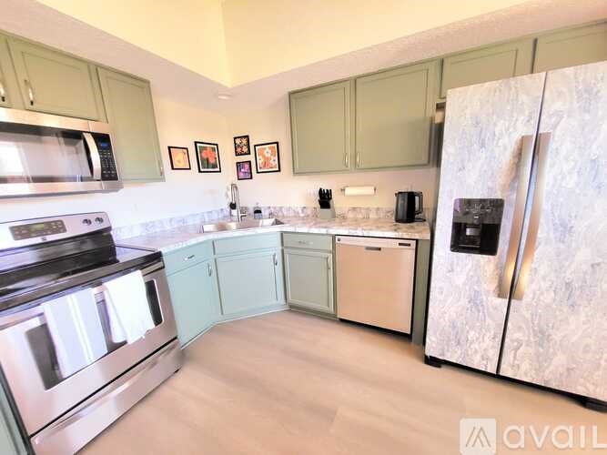 A kitchen with a refrigerator, oven, and microwave.