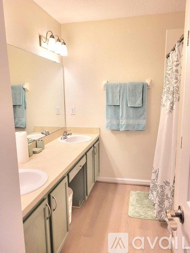 A bathroom with a sink, mirror, and towel.