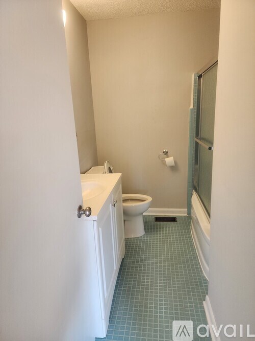 A bathroom with a toilet, sink, and mirror.