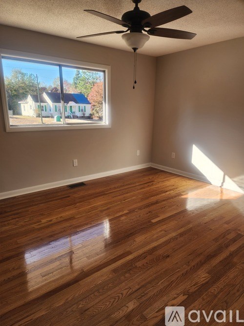A room with wooden floors and a ceiling fan.