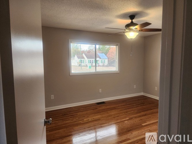 A room with a white door and a white cabinet with a shelf.