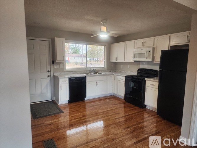 A white pedestal sink with a round mirror above it.