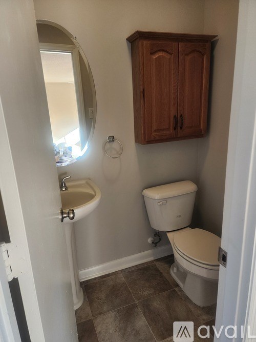A bathroom with a toilet, sink and medicine cabinet.