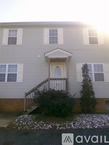 A grey house with a white door and windows.