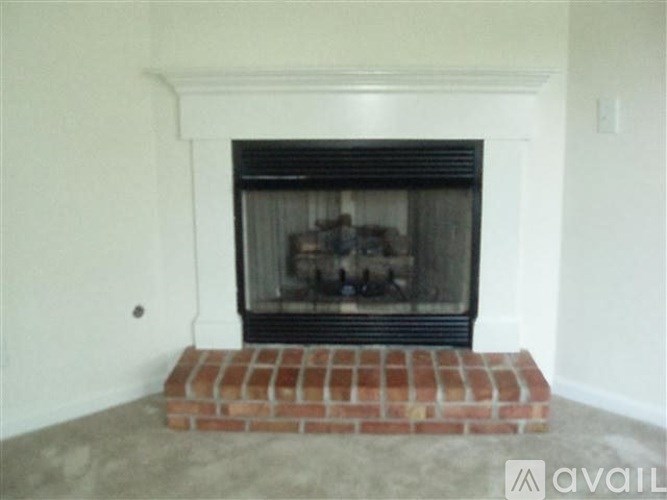 A fireplace with a brick base in a room.