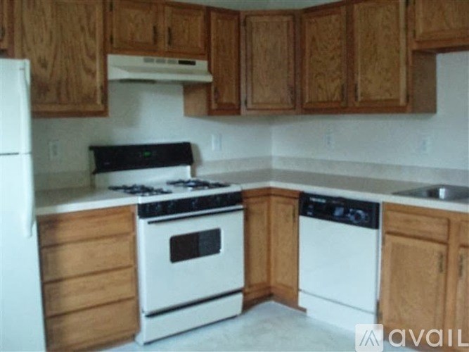 A kitchen with wooden cabinets and white appliances.