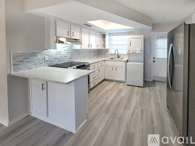 A kitchen with a white countertop and a tile backsplash.