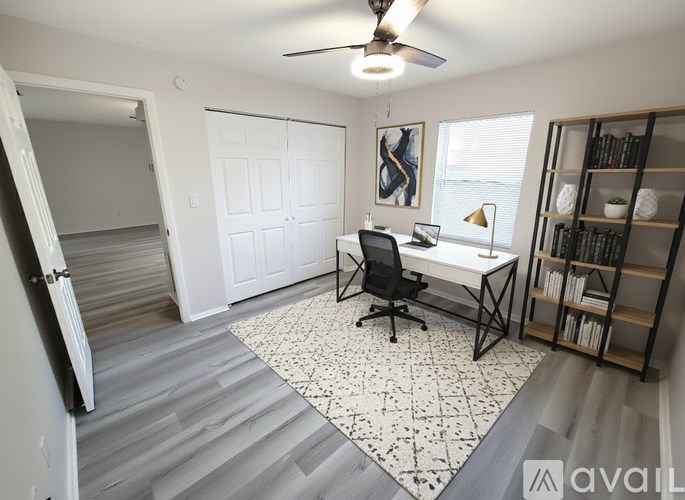 A room with a desk and a chair in it.