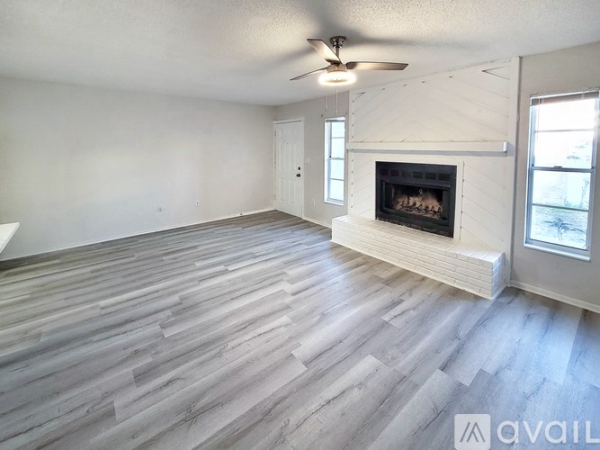 A spacious living room with a fireplace and hardwood flooring.