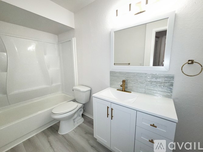 A white bathroom with a toilet, sink, and tub.