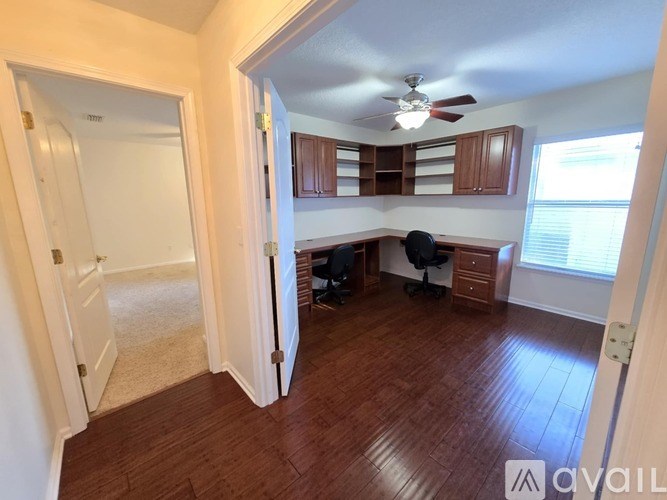 A room with wooden floors and a ceiling fan.