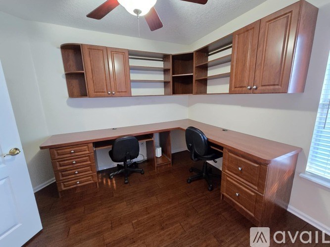 A room with a desk and two chairs.
