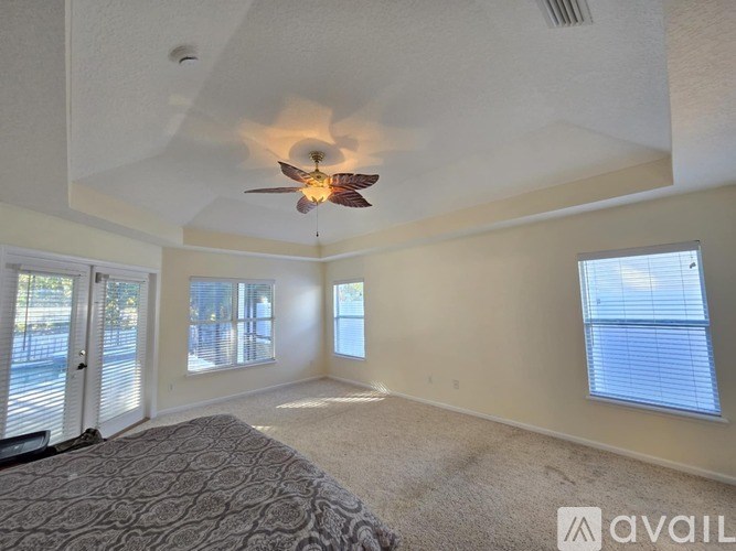 A bedroom with a ceiling fan and a large bed.