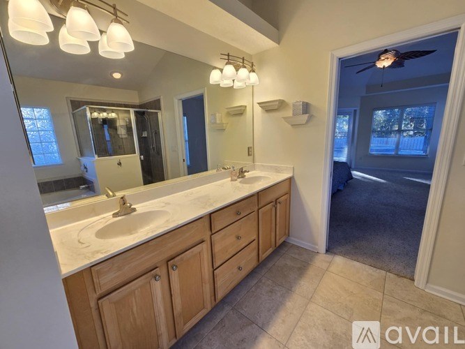 A bathroom with a double sink vanity and a large mirror.