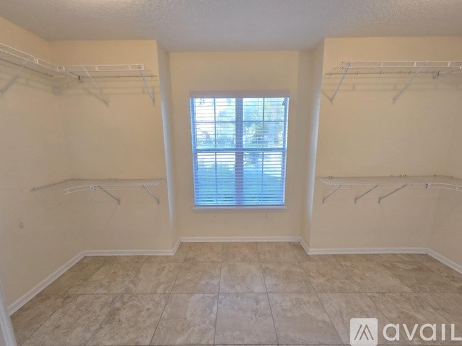 A room with a window and clothes hangers.