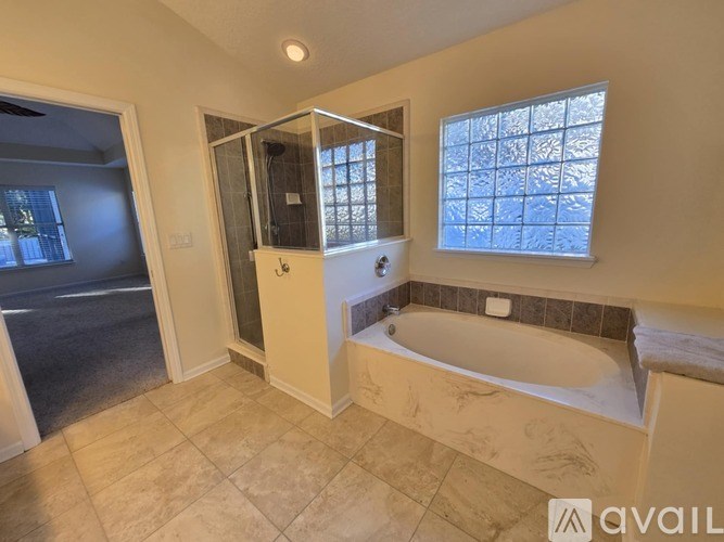 A bathroom with a tub, shower, and a window.