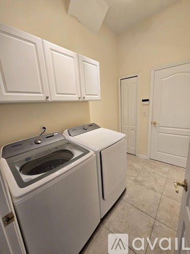 A small laundry room with a washer and dryer.
