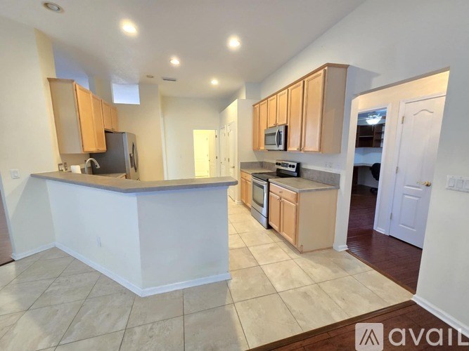 A kitchen with a white counter and wooden cabinets.