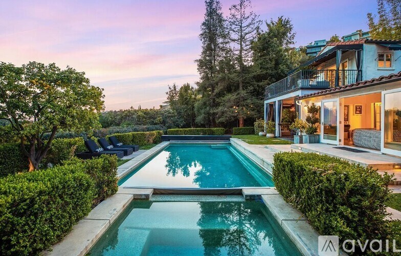 A pool in a backyard with a house in the background.