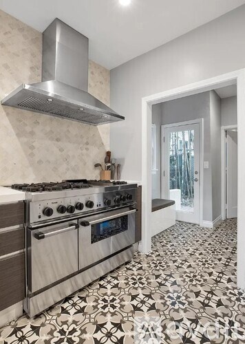 A modern kitchen with a stove top oven and a hood.