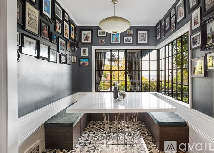 A dining room with a table surrounded by chairs and pictures on the wall.