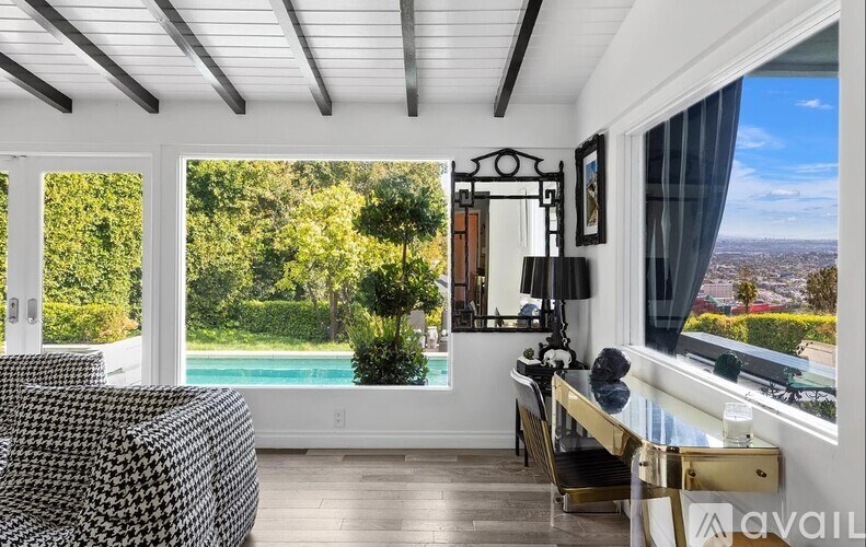 A living room with a black and white checkered chair and a gold console table.
