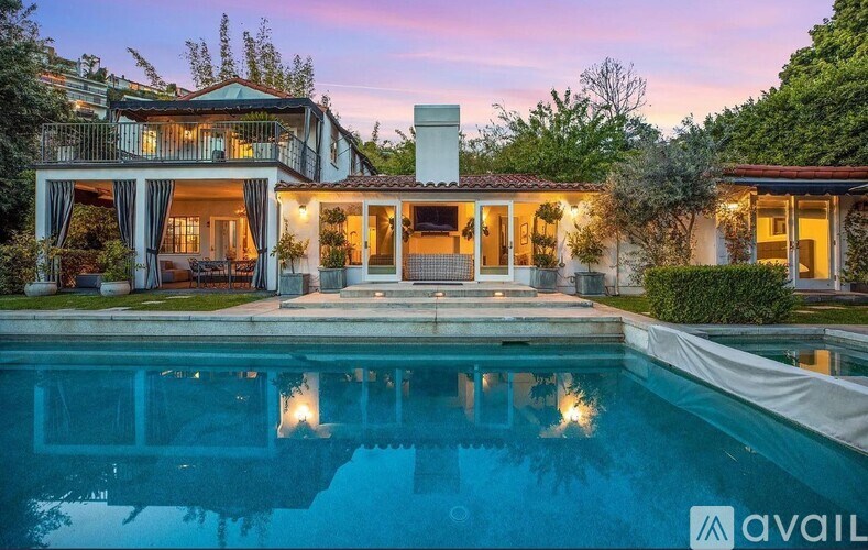 A house with a pool in front of it.