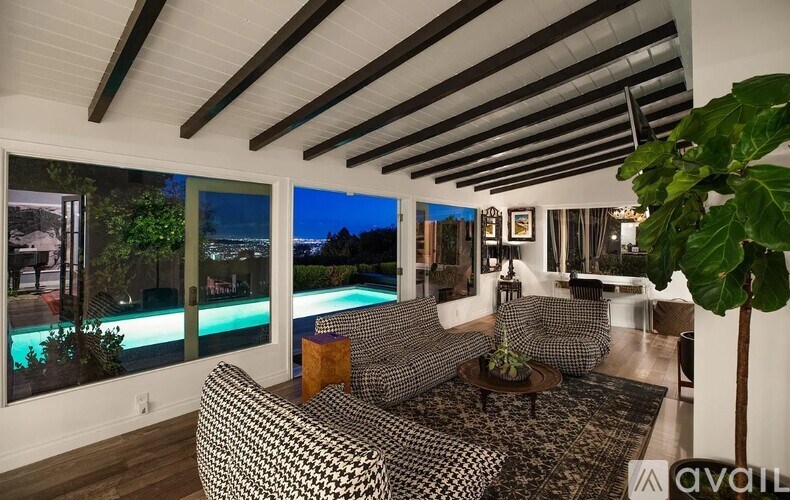 A living room with a pool outside the window.
