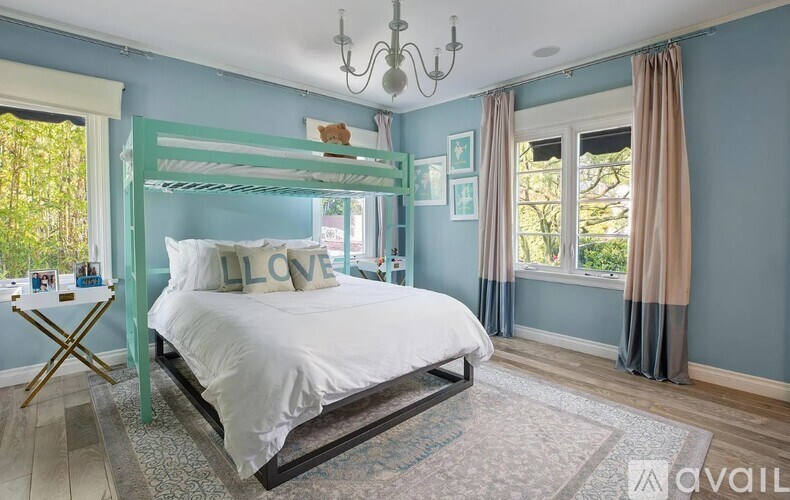 A bedroom with a white bed and a chandelier.